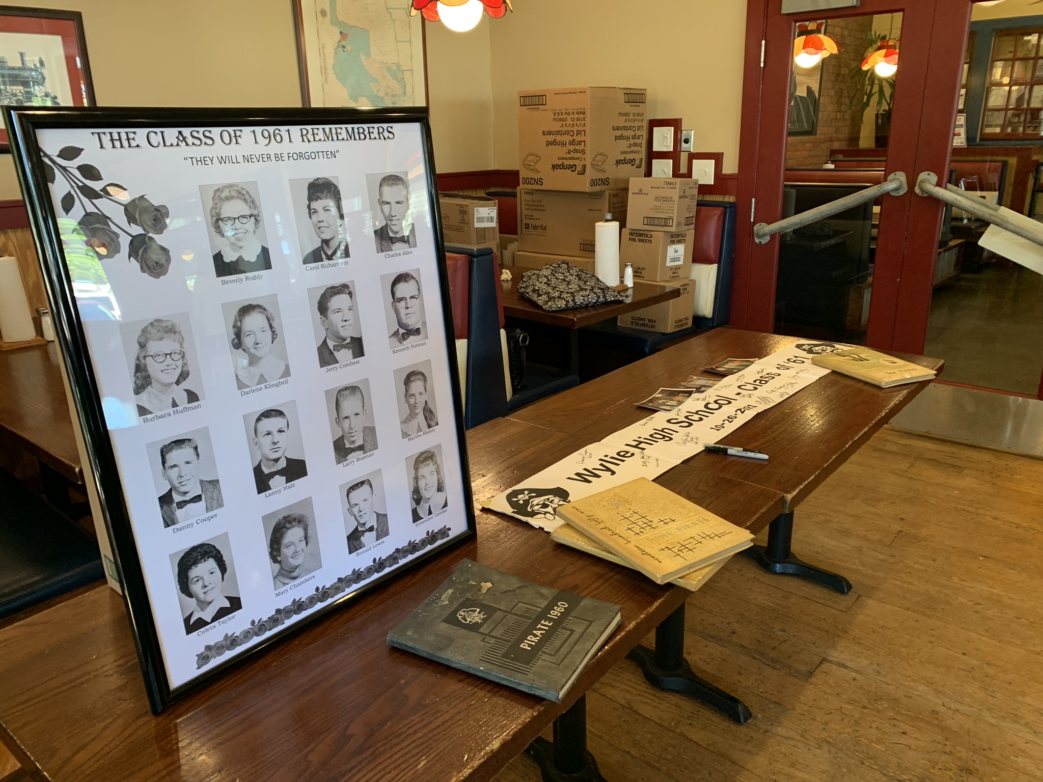 Memory Table with poster remembering the classmates we have lost, year books, and a sign uses since ???.